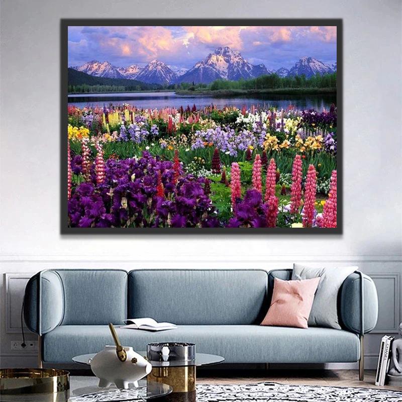 Kleurrijke bloemen aan de oever van de rivier onder de besneeuwde bergtoppen Schilderen op Nummers